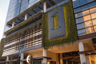 Moss covered 1 Hotels logo on building